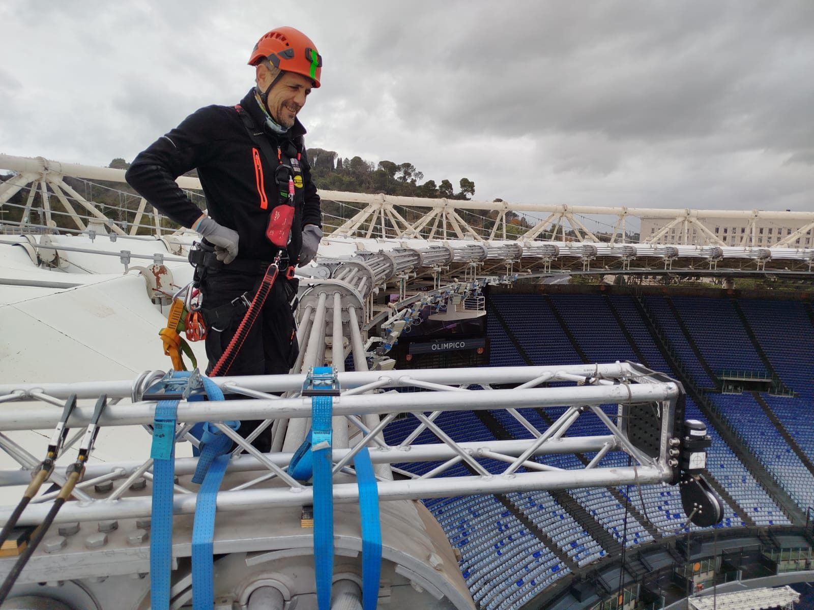 Tecnico al lavoro su una struttura con vista sullo stadio.