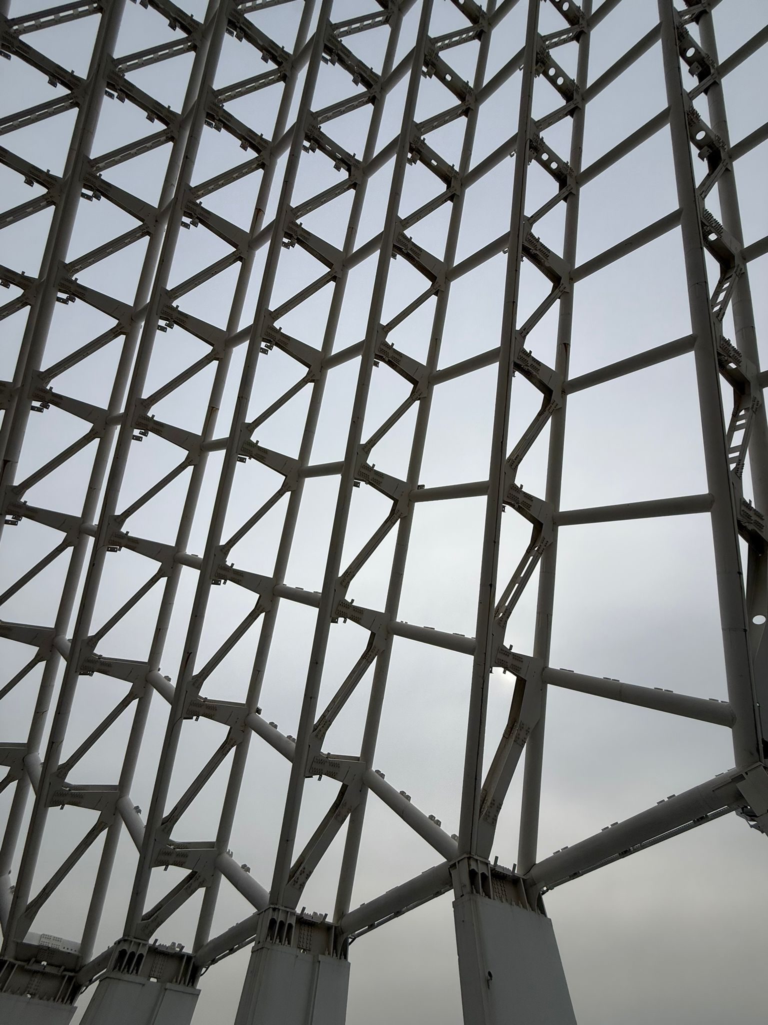 Facciata geometrica di travi reticolari controluce.